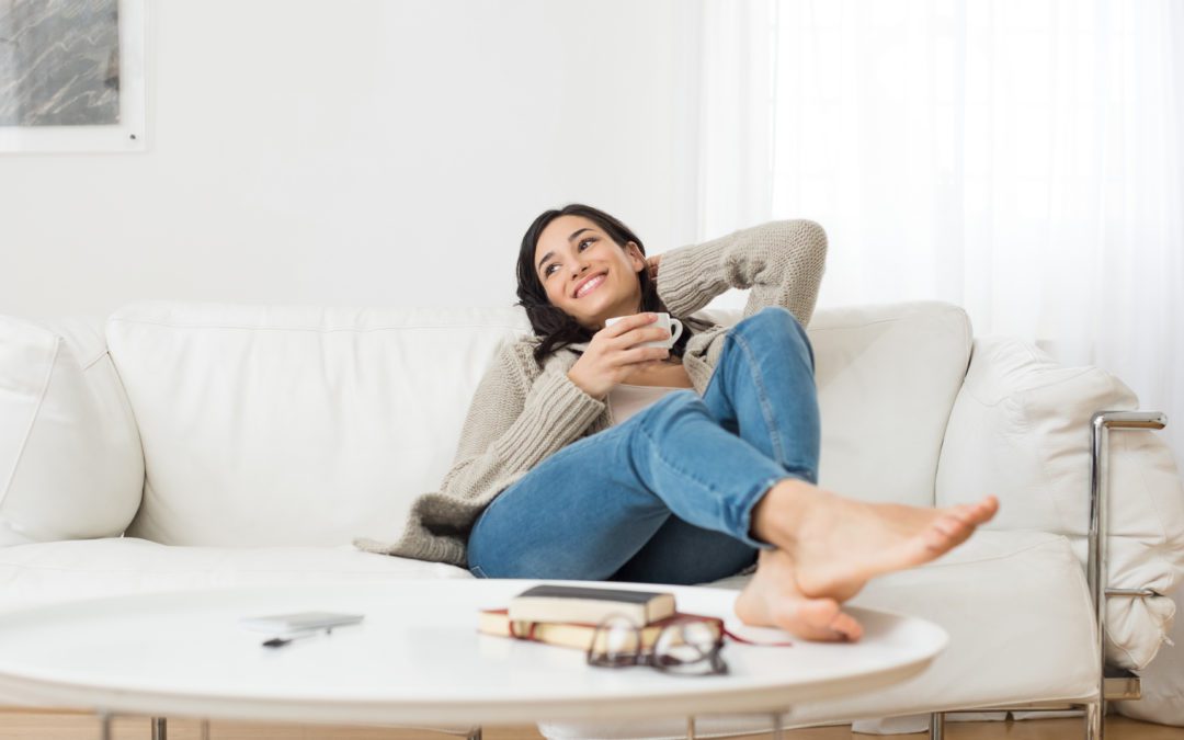 Woman relaxing on her couch with her feet on the coffee table